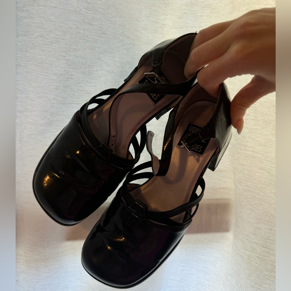 Black Mary Jane style shoes with a glossy finish